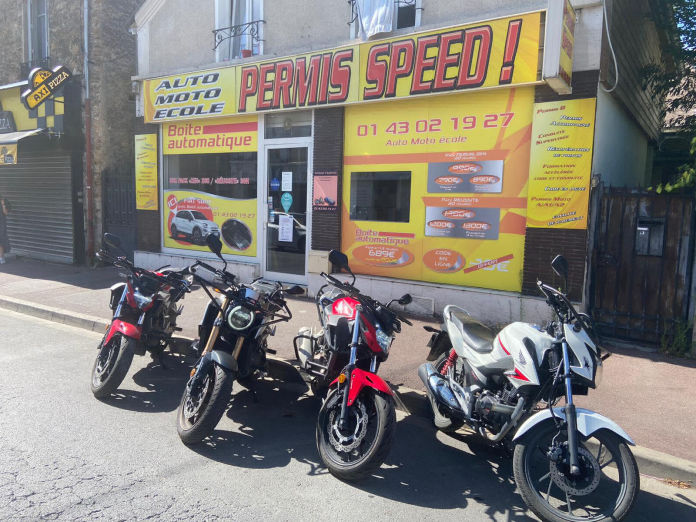 La véritable façade jaune et rouge de Speed Permis, avec les motos devant l’agence au Raincy